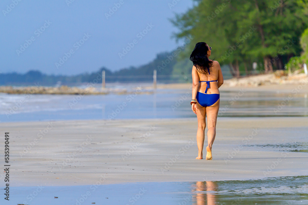 Woman shape big walk play with swimsuit at beach