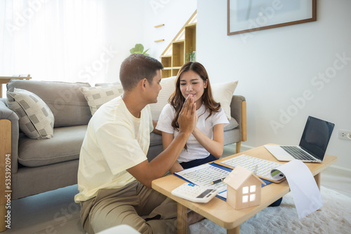 Asian couple in home or house. To compare prices, interest, credit. Include laptop, calculator and document on table. Concept for marriage, loan, finance, insurance, mortgage, real estate and property © DifferR