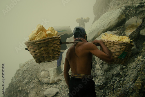 Minners carrying sulfur on top of Kawah ijen through toxic fumes