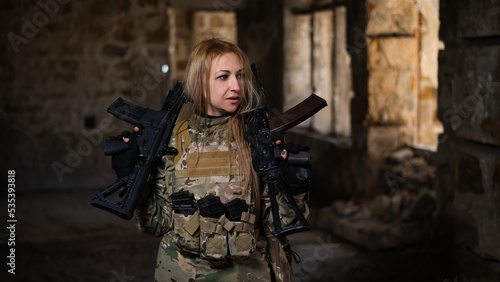 Blonde woman in army uniform holding a firearm in an abandoned building.  © Михаил Решетников