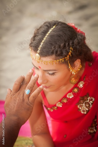 Woman in sari getting a Tilaka on her forehead photo
