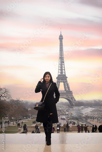 Woman standing on terrace with eiffel tower in background, paris photo