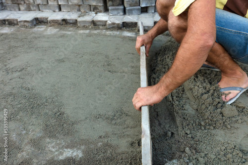 Worker leveling the foundation with a wooden board photo