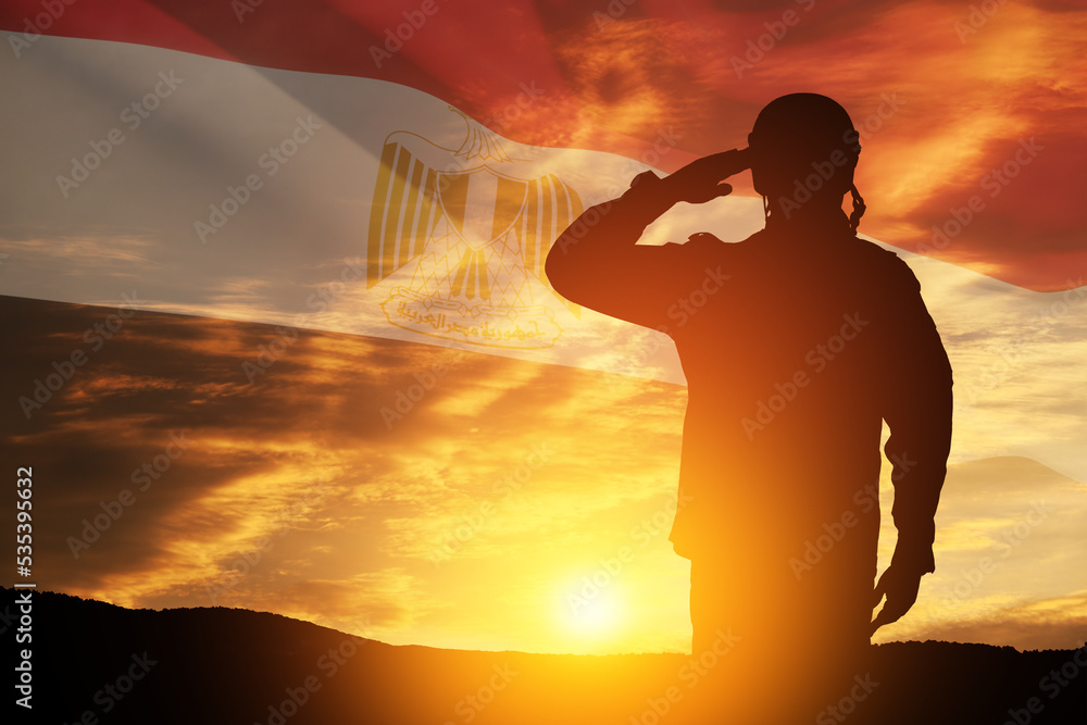 Double exposure of silhouette of a solider and the sunset or the sunrise against flag of Egypt. Closeup. Greeting card for Independence day, Memorial Day, Armed forces day, Sinai Liberation Day.