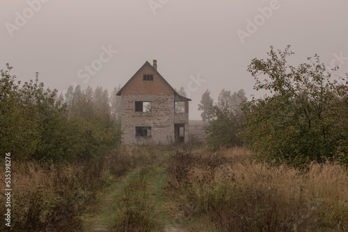 small abandoned brick house in autumn apple orchard