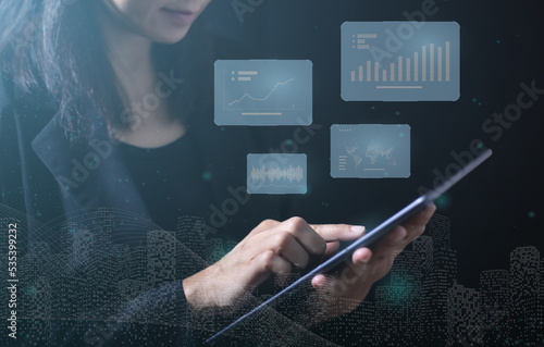 Woman using tablet on dark background. Displays through a virtual screen. Communication and connection of the future world.