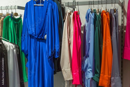 Bright elegant women's dresses on hangers in the store. Fashion & Style. © Анна Демидова