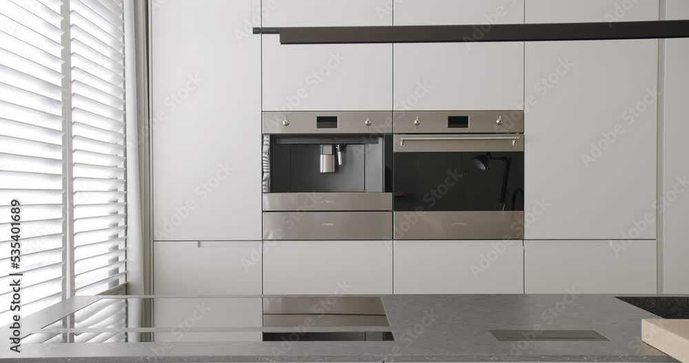 Modern kitchen room in minimalist apartment with dining area of natural wood, Black Kitchen sink and faucet. Home Interior in white an grey colors with concrete, comfortable equipment. Modern kitchen room in minimalist apartment with dining area of natural wood, Black Kitchen sink and faucet. Home Interior in white an grey colors with concrete, comfortable equipment.