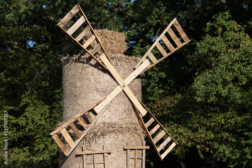 Stary słomiany i drewniany wiatrak na wsi.