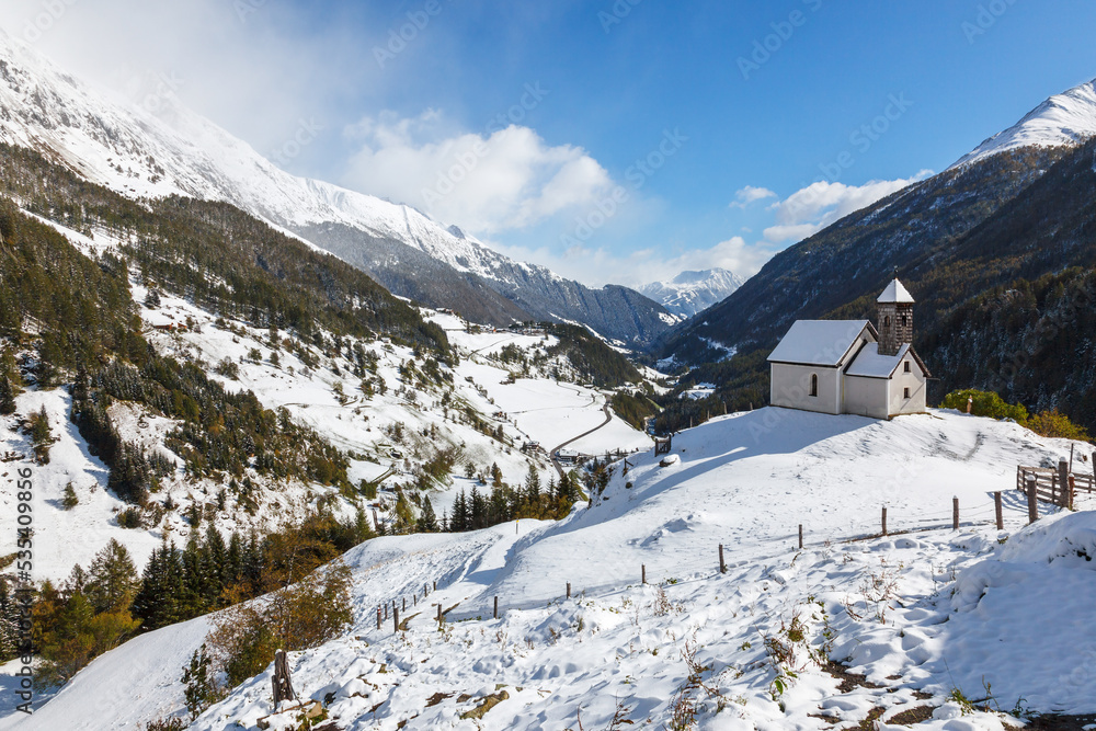 Alp valley with a church at the winter