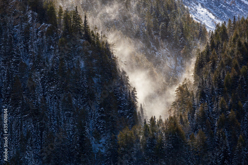 Snow blowing into a mountain ravine photo
