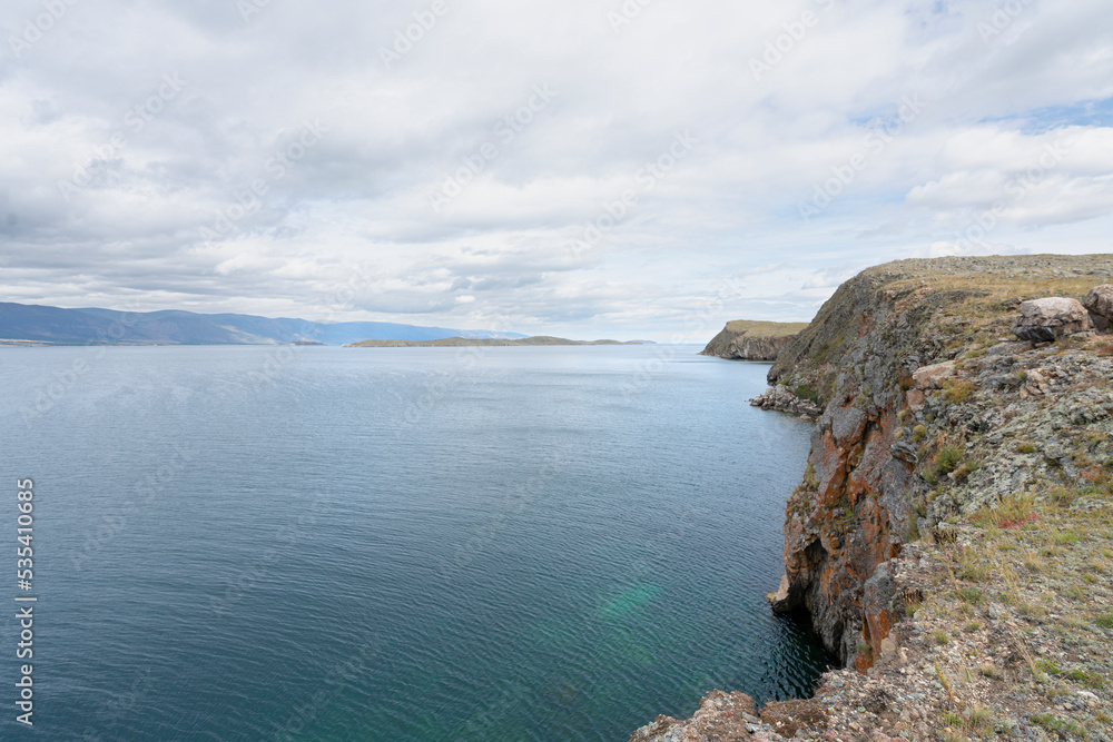 Beautiful summer landscape of Baikal Lake on sunny day. View of the rocky cape Beautiful summer landscape of Baikal Lake on sunny day. View of the rocky cape