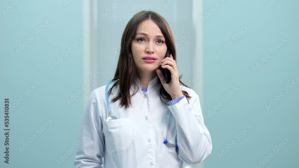 Young woman general practitioner provides telephone consultation at break. Dark-haired doctor advises patient to take new medicines for quicker recovery at flu Young woman general practitioner provides telephone consultation at break. Dark-haired doctor advises patient to take new medicines for quicker recovery at flu