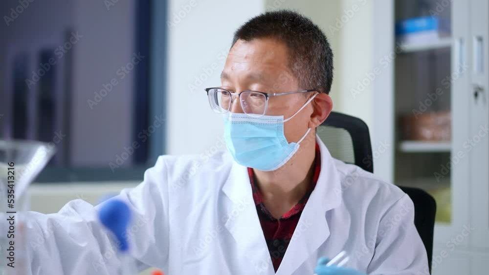 chinese man doctoro doing chemical experiment in library chinese man doctoro doing chemical experiment in library