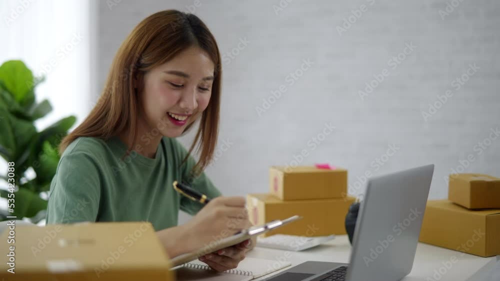 Young owner business woman received orders from clients and preparing products in parcel cardboard box packaging at home. Young owner business woman received orders from clients and preparing products in parcel cardboard box packaging at home.