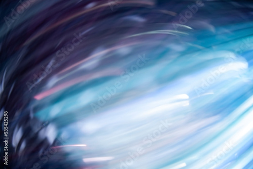 Defocused light motion. Blur radiance. Smeared fluorescent beams. Bokeh luminous neon purple blue white color glowing rays texture on dark black abstract free space background.