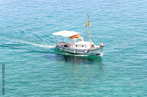 Small fishing boat on the crystal clear beach of Corfu, Greece