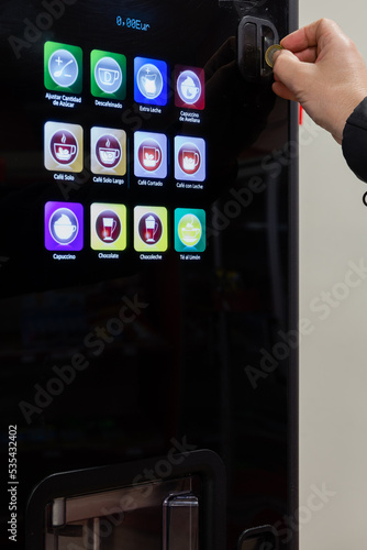 Plakat Man's hand inserts euro into vending machine