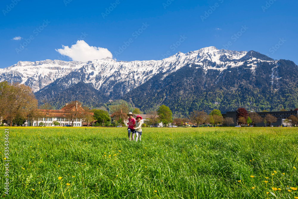 Girls running around in the grass in Interlaken, Switzerland Girls running around in the grass in Interlaken, Switzerland