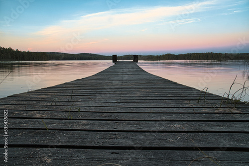 Fototapeta Naklejka Na Ścianę i Meble -  Wooden jetty reaching into a swedish lake at blue hour. Nature from Scandinavia