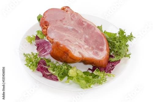 Boiled-smoked pork knuckle on the lettuce leaves on dish