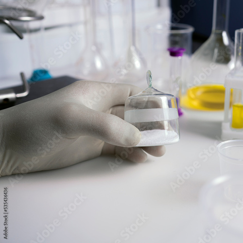 Close up of the hand of a scientist working with laboratory samples of nutritional supplements additive.