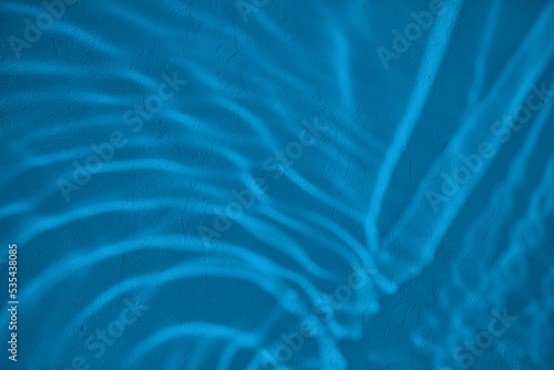 Shadow and light water caustic effect on blue concrete wall texture with roughness and irregularities. Abstract trendy nature concept background. Copy space for text overlay, poster mockup flat lay 