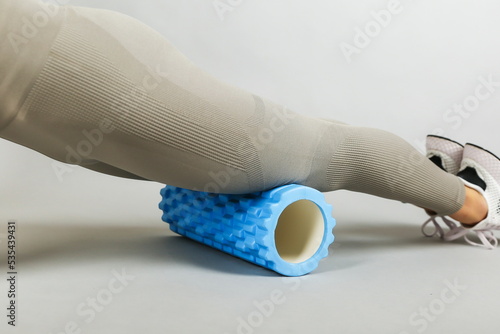 woman doing exercises with yoga foam grid roller