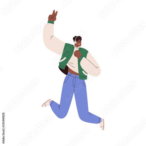 Black man in wireless headphones, listening to music and jumping up. Happy ex...