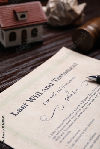 Last will and testament near house model on wooden table, closeup