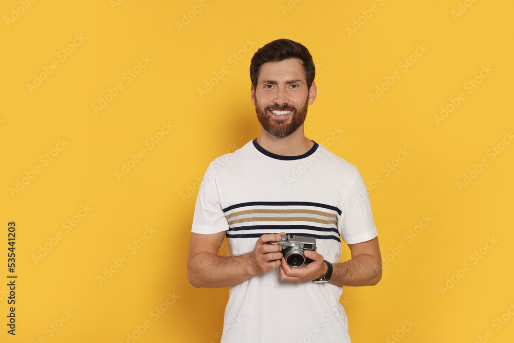 Man with camera on yellow background. Interesting hobby Man with camera on yellow background. Interesting hobby