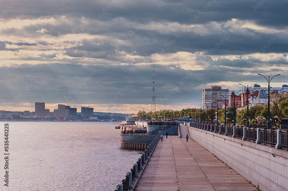 View of the embankment of the city of Blagoveshchensk, Russia, against a stormy sky with gray clouds before the rain. Thunderclouds in the sky. Across the Amur River is the city of Heihe, China