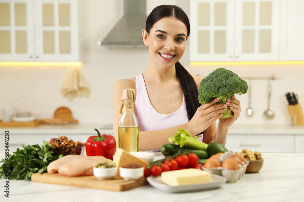 Happy woman with different products in kitchen. Keto diet Happy woman with different products in kitchen. Keto diet