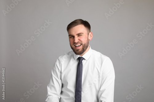 Portrait of happy businessman on light grey background. Personality concept