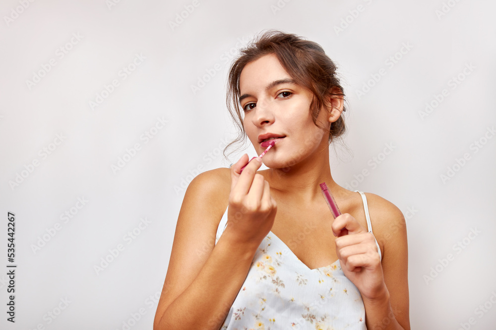 Beautiful girl uses red lipstick. Selection and use of cosmetics. Beautiful girl uses red lipstick. Selection and use of cosmetics.