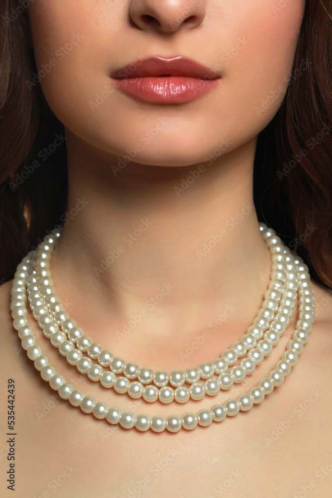 Young woman wearing elegant pearl necklace, closeup