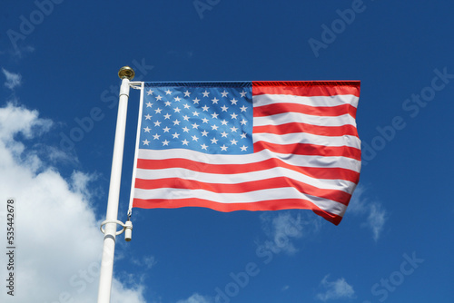 American flag waving on a blue sky background.