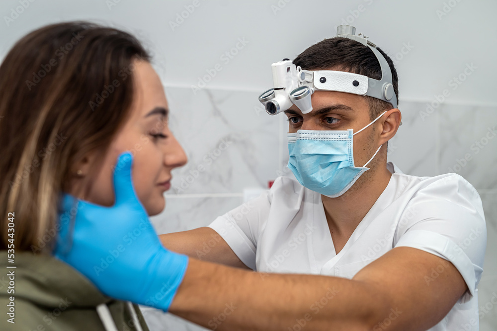 doctor examines the throat of a female patient who has opened her mouth to check her throat. doctor examines the throat of a female patient who has opened her mouth to check her throat.