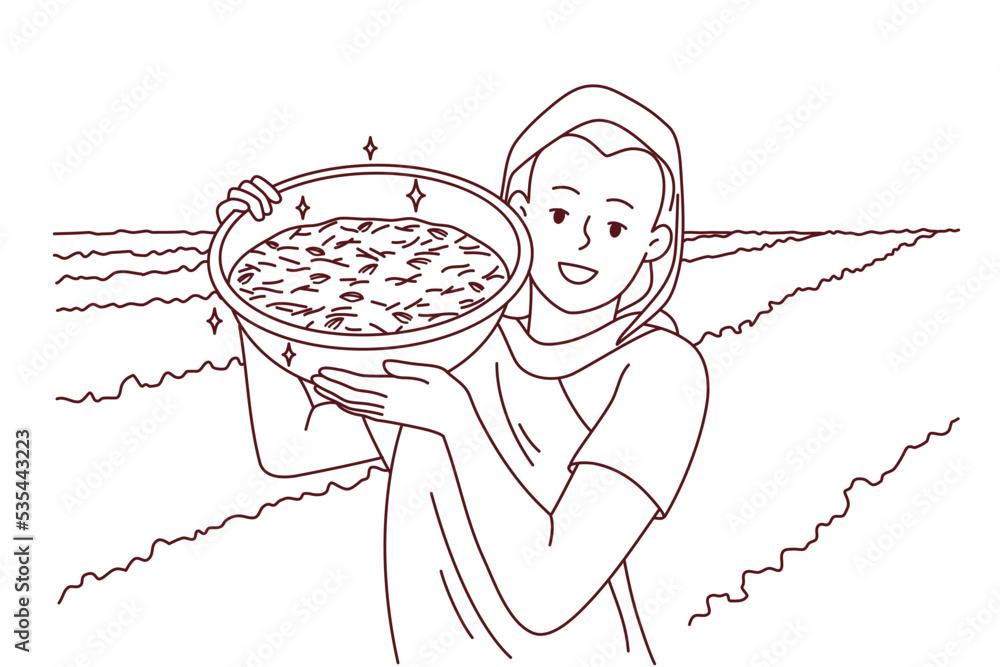 Smiling indian woman in traditional clothes show bowl working in field ...