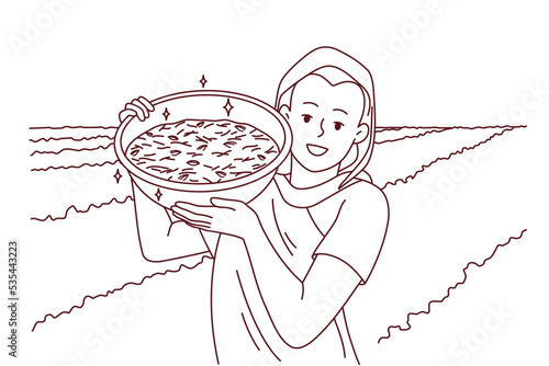 Smiling indian woman in traditional clothes show bowl working in field in countryside. Happy female worker collecting crop in rural grassland. Farming concept. Vector illustration. 