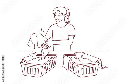 Woman sorting dirty clothes for washing. Girl gathering laundry in baskets in laundromat. Housework and housekeeping. Vector illustration. 