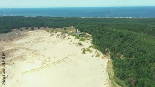 Drone footage of One of the most famous dunes in Lithuania, video of mass of sand created this unique landscape beside baltic sea, sun clock is installed on the side of the dune photo