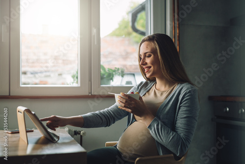 young adult caucasian woman eats fruit salad and using digital tablet at home Free Download young adult caucasian woman eats fruit salad and using digital tablet at home - GFXLoad