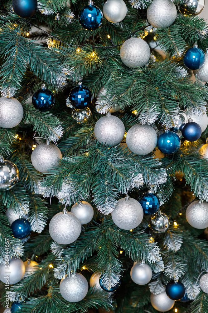 Christmas tree with blue and silver toys. Festively decorated Christmas tree with garlands. Symbol of the new year. Christmas tree with blue and silver toys. Festively decorated Christmas tree with garlands. Symbol of the new year.