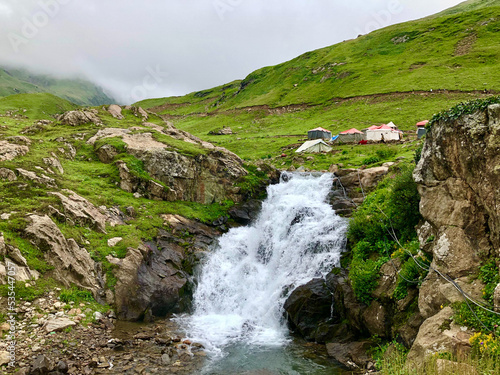 Fresh waterfall in grassy and rocky hills