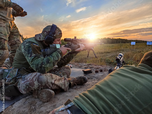 Ukrainian army sniper soldier training at shooting range with American rifle M14 with scope, beautiful environment landscape view with sunset light