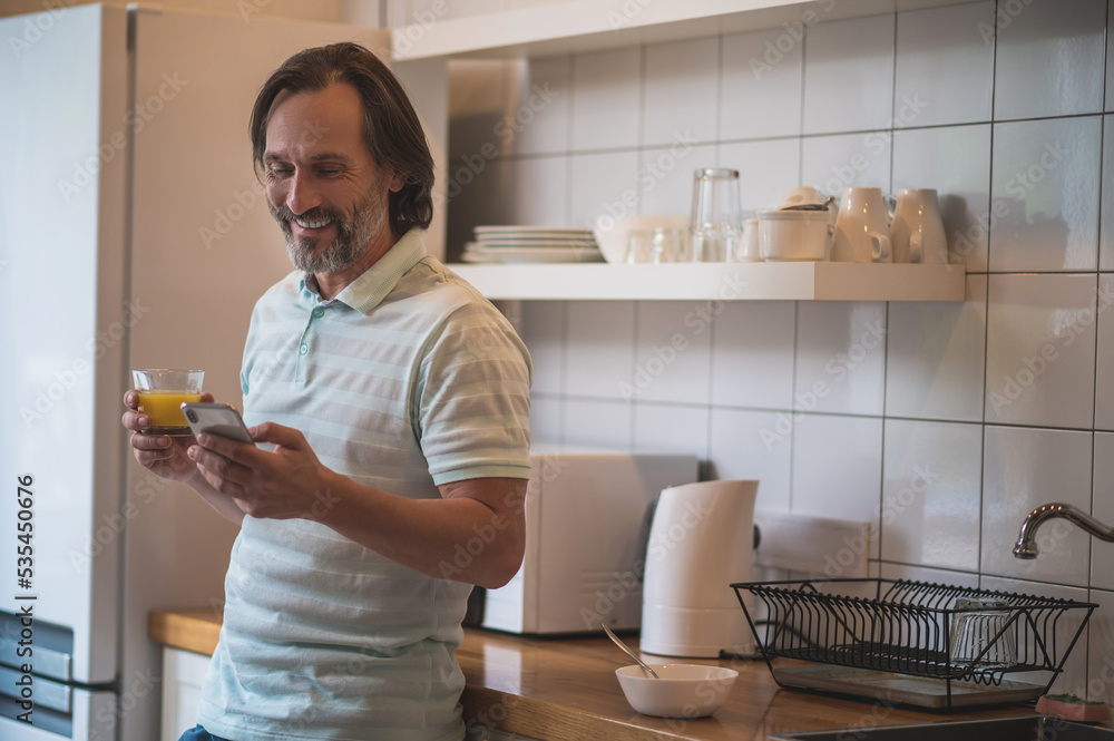 Smiling contented man having breakfast in the kitchen Smiling contented man having breakfast in the kitchen