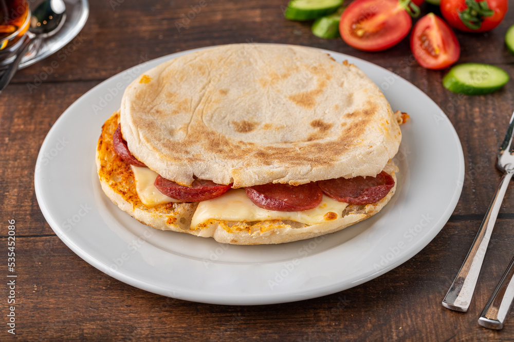 Flatbread toast with salami, turkish sausage and cheddar on a dark stone table Flatbread toast with salami, turkish sausage and cheddar on a dark stone table