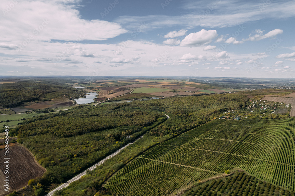 Aerial top view of the black soil autumn fields with small lake and cloudy sky. Drone shot of an autumn rural agriculture fields with harvest. Aerial top view of the black soil autumn fields with small lake and cloudy sky. Drone shot of an autumn rural agriculture fields with harvest.