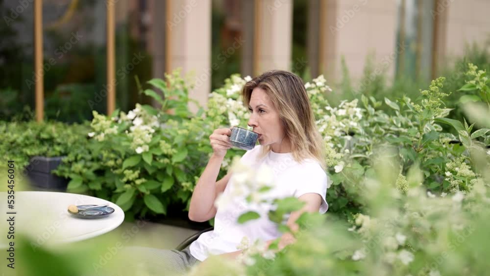 single middle-aged woman is enjoying good taste of hot coffee or tea in city cafe, portrait single middle-aged woman is enjoying good taste of hot coffee or tea in city cafe, portrait